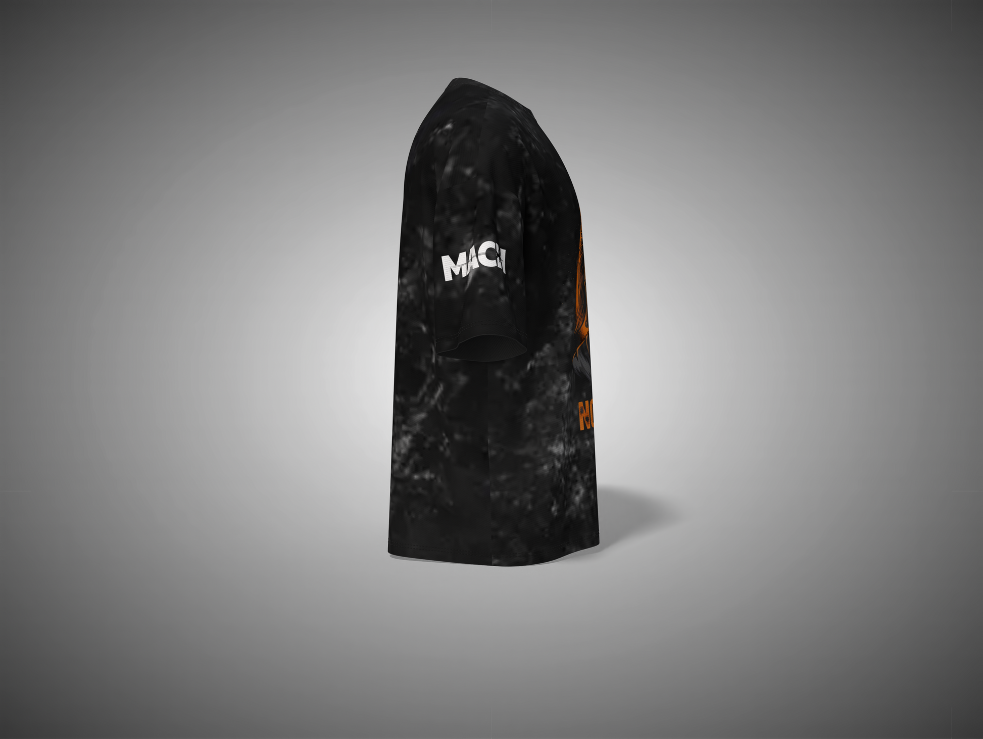 Black and orange patterned t shirt with 'MAC' branding on a gray background