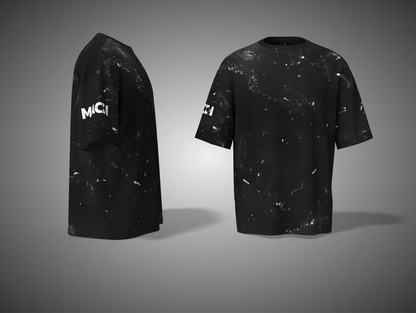 Black t-shirt with white speckles and 'MCI' branding on a gray background