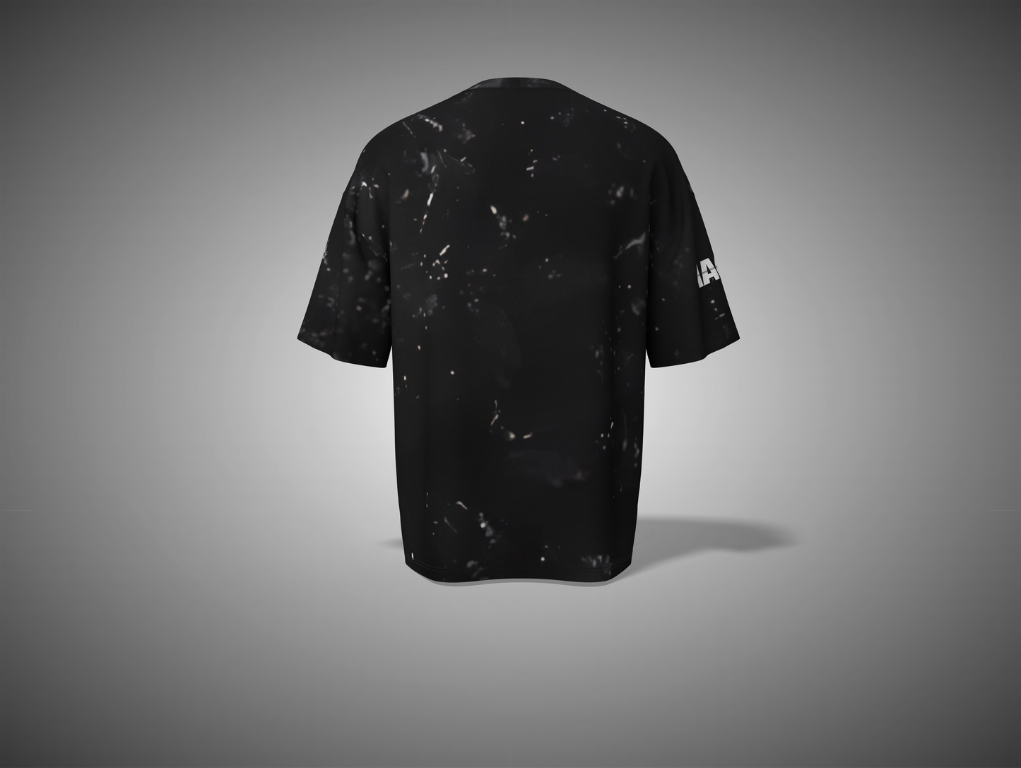 Black t-shirt with white speckles on a gray background
